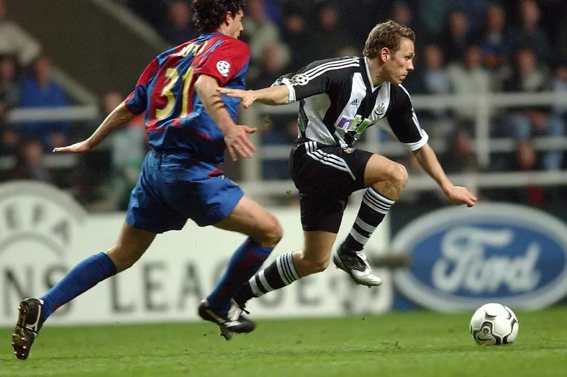 Craig Bellamy del Newcastle y Thiago Motta del Barcelona corriendo por la pelota en la Champions’ League en St James’ Park  